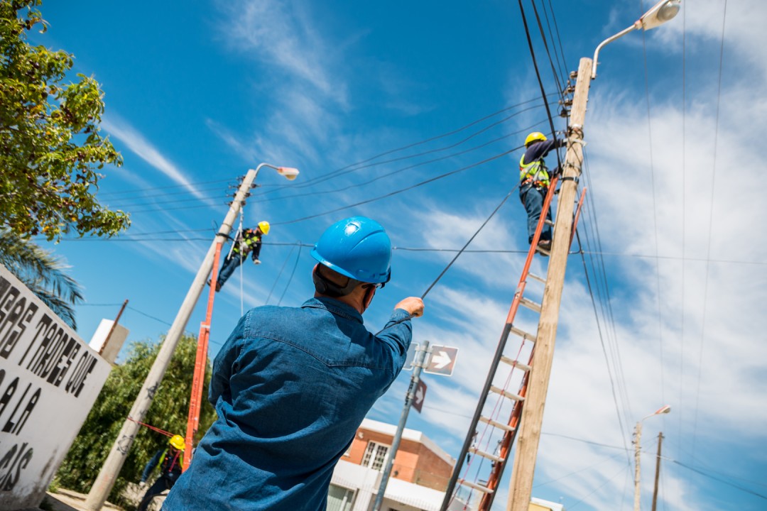 Técnico ajustando caja de empalme de fibra óptica en poste